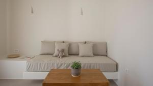 a room with a couch with a teddy bear on it at Kalami Suites in Livadi