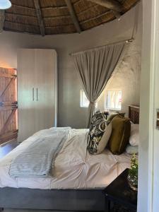 a bedroom with a large bed with pillows on it at Dennegeur Guesthouse in Somerset East