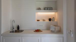 a kitchen counter with a sink and a light at Kalami Suites in Livadi
