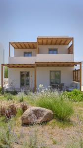 a house with a rock in front of it at Kalami Suites in Livadi