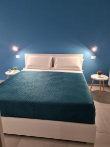 1 dormitorio azul con 1 cama y 2 mesas en CIVICO 66 en Palermo