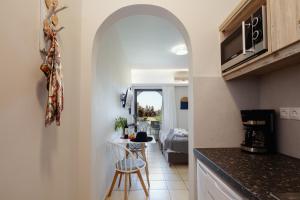 uma cozinha com um arco que leva a uma sala de estar em Green View Studios & Apartments em Dhamnóni