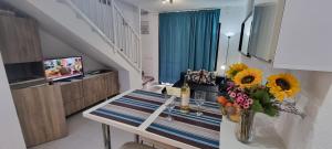 a living room with a table with sunflowers on it at HATO Holiday Home Fuerteventura in Costa Calma