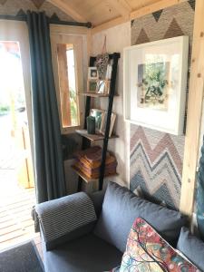a living room with a couch and a window at Relax in the unique and cosy Off-grid Eco Shepherd's hut Between Heaven and Earth in Mountshannon