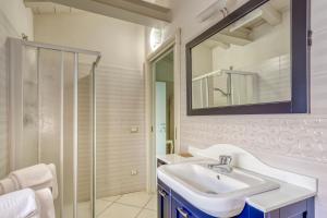 a white bathroom with a sink and a mirror at Villa Liberty in Boario Terme