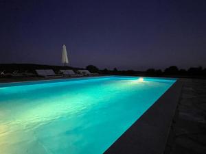 una piscina por la noche con una piscina iluminada en At Home In Istria- Villa Stancia Cicada, en Žminj