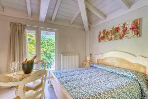 a bedroom with a bed and a table and a window at Villa Liberty in Boario Terme
