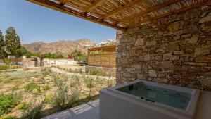 a bath tub sitting next to a stone wall at Kalami Suites in Livadi