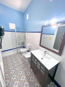 a blue bathroom with a sink and a toilet at Hostal El Faro in Chipiona