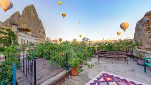 a balcony with hot air balloons flying in the sky at Roc Of Cappadocia in Göreme