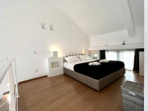 - une chambre blanche avec un grand lit et du parquet dans l'établissement Modern Loft, à Milan