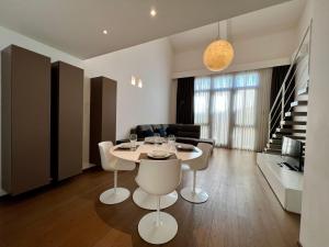 - un salon avec une table et des chaises blanches dans l'établissement Modern Loft, à Milan