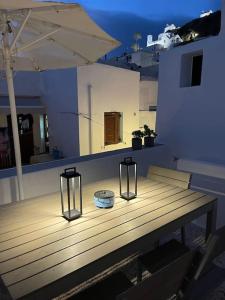 a wooden table with two candles and an umbrella at Traditional Cosy Home in Ios Chora