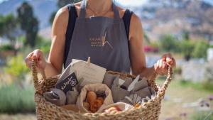 a woman is holding a basket of food at Kalami Suites in Livadi