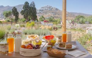 un tavolo con piatti di cibo e bottiglie di succo d'arancia di Kalami Suites a Livadi