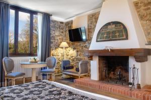 sala de estar con chimenea y TV en Residenza le Colline del Paradiso en Bivigliano