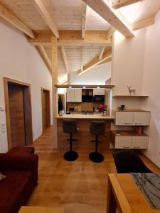 una cucina con bancone e due sgabelli in una stanza di Hochalmbahnen Chalets Rauris 1-20 WE4, Maislaufeldweg 1r OG a Rauris