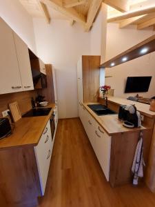 uma cozinha com armários brancos e bancadas de madeira em Hochalmbahnen Chalets Rauris 1-20 WE4, Maislaufeldweg 1r OG em Rauris