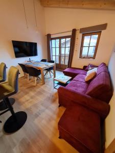 uma sala de estar com um sofá roxo e uma mesa em Hochalmbahnen Chalets Rauris 1-20 WE4, Maislaufeldweg 1r OG em Rauris