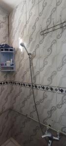 a bathroom with a shower and a light on the wall at Mehdi House in Chefchaouen