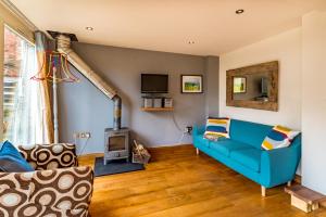 Ottery St Mary Cottages في أوتري سانت ماري: غرفة معيشة مع أريكة زرقاء ومدفأة