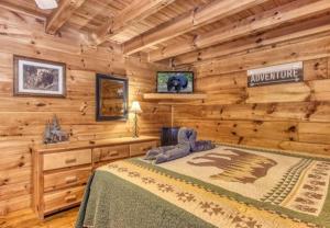 ein Schlafzimmer mit einem Bett in einem Blockhaus in der Unterkunft Lazy Bear Cabin in Sevierville