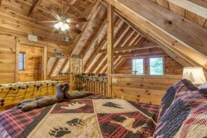 a log cabin bedroom with a bed and a ceiling fan at Lazy Bear Cabin in Sevierville +16 photos
