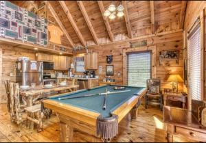 a pool table in a room with a kitchen at Lazy Bear Cabin in Sevierville