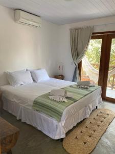 - une chambre avec un grand lit blanc et une fenêtre dans l'établissement Casa Éolica, à Barra Grande