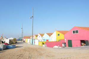 uma fila de casas coloridas ao lado de uma estrada de terra em Blue Beach Apartment - Caminhos de Santiago-Airport em Praia de Angeiras