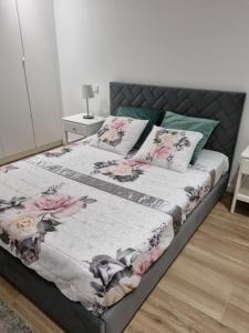 a bedroom with a bed with pink flowers on it at Blue Beach Apartment - Caminhos de Santiago-Airport in Praia de Angeiras