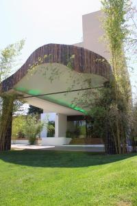 ニームにあるHÔTEL C SUITES chambres spacieusesの草原の上に緑の屋根を持つ建物