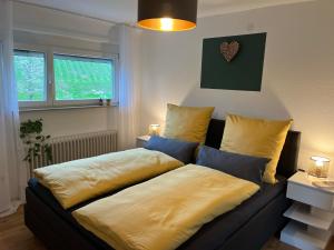 a bed with yellow sheets on a couch in a room at Revier No11 in Durbach