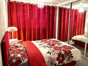 een slaapkamer met rode gordijnen en een bed met een dekbed bij Lovely and affordable house closer to the sea in Hartlepool
