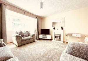 een woonkamer met een bank en een televisie bij Lovely and affordable house closer to the sea in Hartlepool