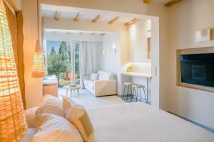 ein Schlafzimmer mit einem Bett und ein Wohnzimmer in der Unterkunft Rarakos Houses Corfu in Korfu-Stadt