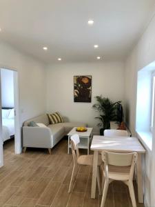 Casa Martins Country Apartment No5 في Freiria: غرفة معيشة مع أريكة وطاولة