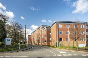 an empty street in front of a brick building at Modern City Living Apartments at Broadgate Park in Nottingham in Nottingham