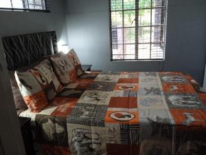 a bedroom with a bed with a quilt on it at African Sky in Marloth Park