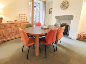 a dining room with a wooden table and chairs at Gildabrook Cottage in Bowness-on-Windermere