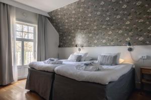 a bedroom with a large bed with a floral wallpaper at Best Western Solhem Hotel in Visby