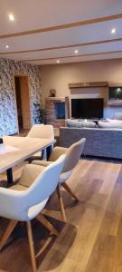 Una sala de estar con mesas y sillas y un sofá. en FERIENHAUS ZUM HOLZMICHEL, en Thale