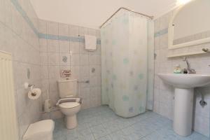 a bathroom with a toilet and a sink at Regina apartments Simotata Sissia in Lourdata +37 photos