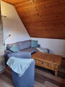 ein Wohnzimmer mit einem Sofa und einem Tisch in der Unterkunft FERIENHAUS ZUM HOLZMICHEL in Thale