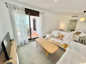 salon z białą kanapą i stołem w obiekcie Oasis & Spa Apartment w mieście Salobreña