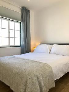 a bedroom with a large white bed with a window at Casa Martins Country Apartment No5 in Freiria