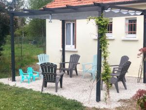 un grupo de sillas y mesas bajo una pérgola en La petite maison des gîtes de Joséphine, en Saint-Dyé-sur-Loire