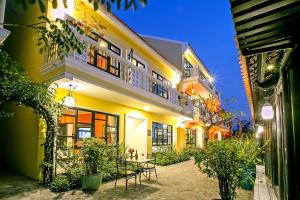 um edifício amarelo com uma mesa em frente em Hoi An Town Home Resort em Hoi An
