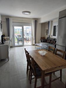a kitchen and living room with a wooden table and chairs at Lilli Deluxe apartment in Nikiti +6 photos