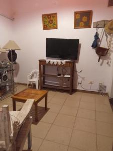 Il comprend un salon doté d'une télévision à écran plat et d'une table. dans l'établissement Casa Balcón de la Ciudad, à San Fernando del Valle de Catamarca